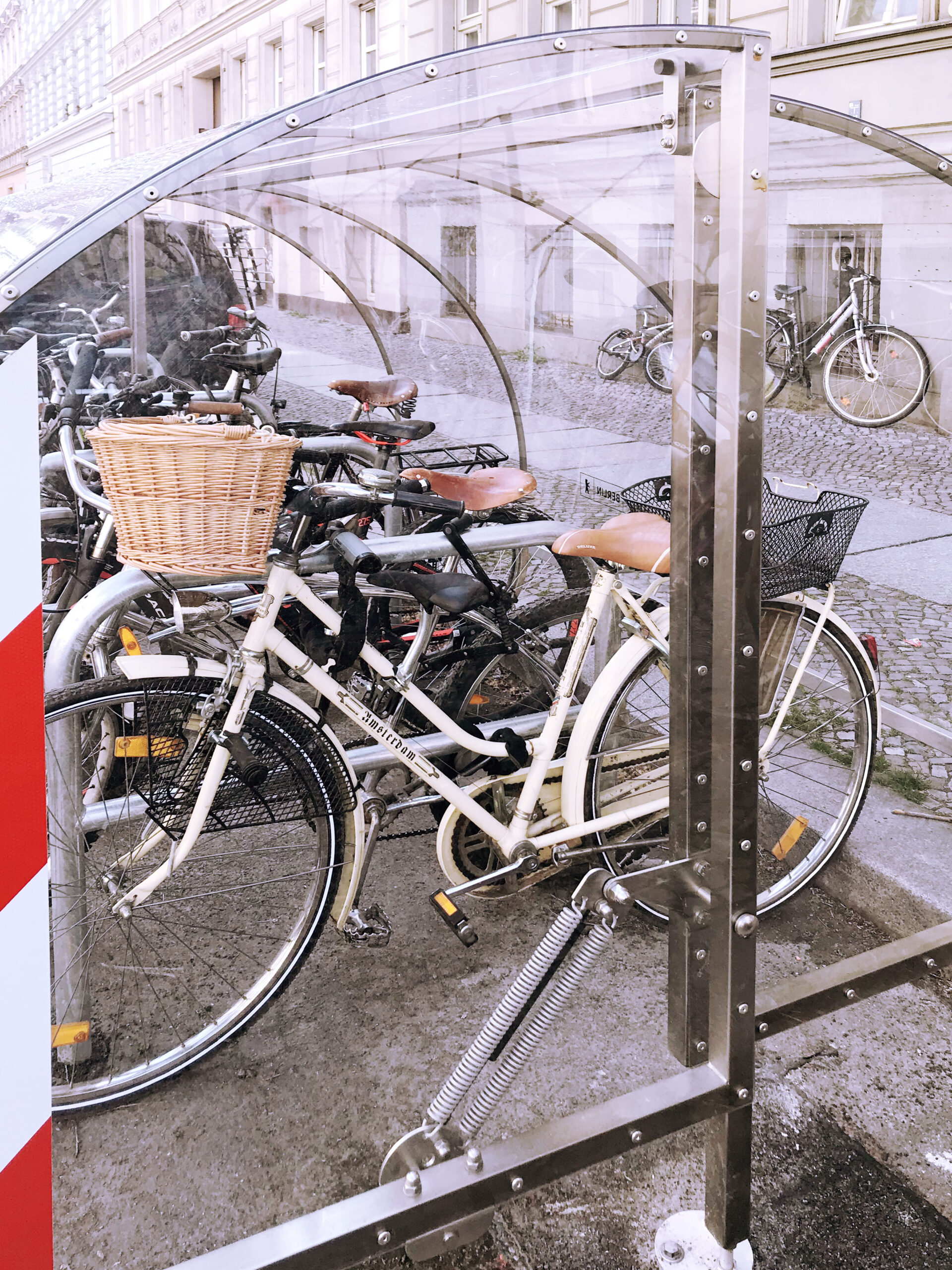 Fahrräder stehen auf einem Fahrradparkplatz in einer transparenten Fahrradgarage.