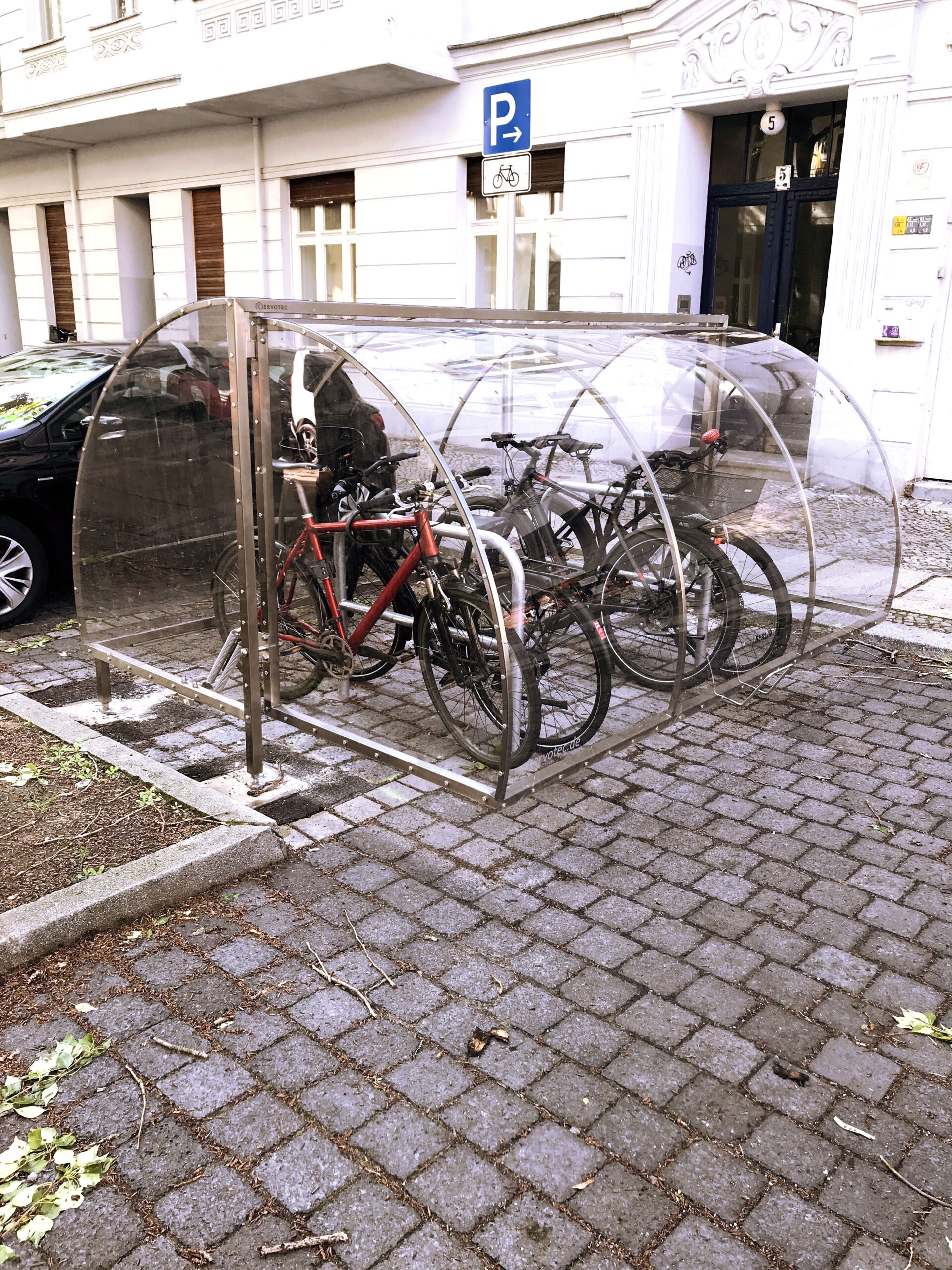 Fahrräder stehen auf einem Fahrradparkplatz in einer transparenten Fahrradgarage.