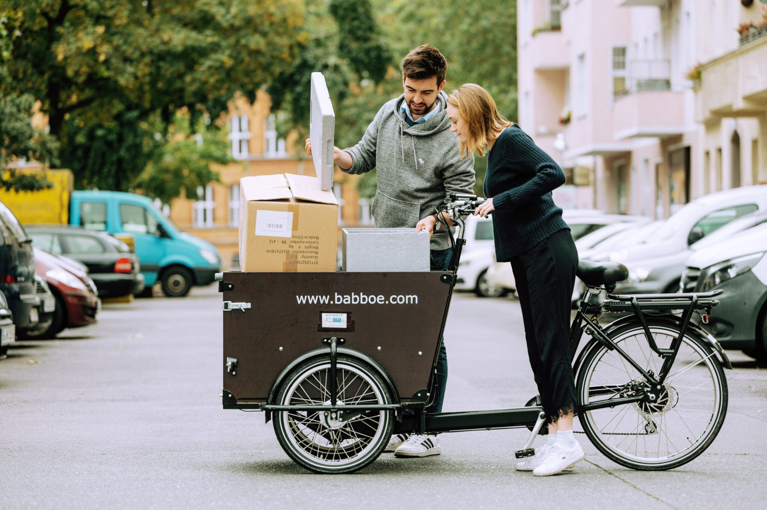 Zwei Personen schauen gemeinsam in eine box, die sich in einem Babboe Lastenrad befindet